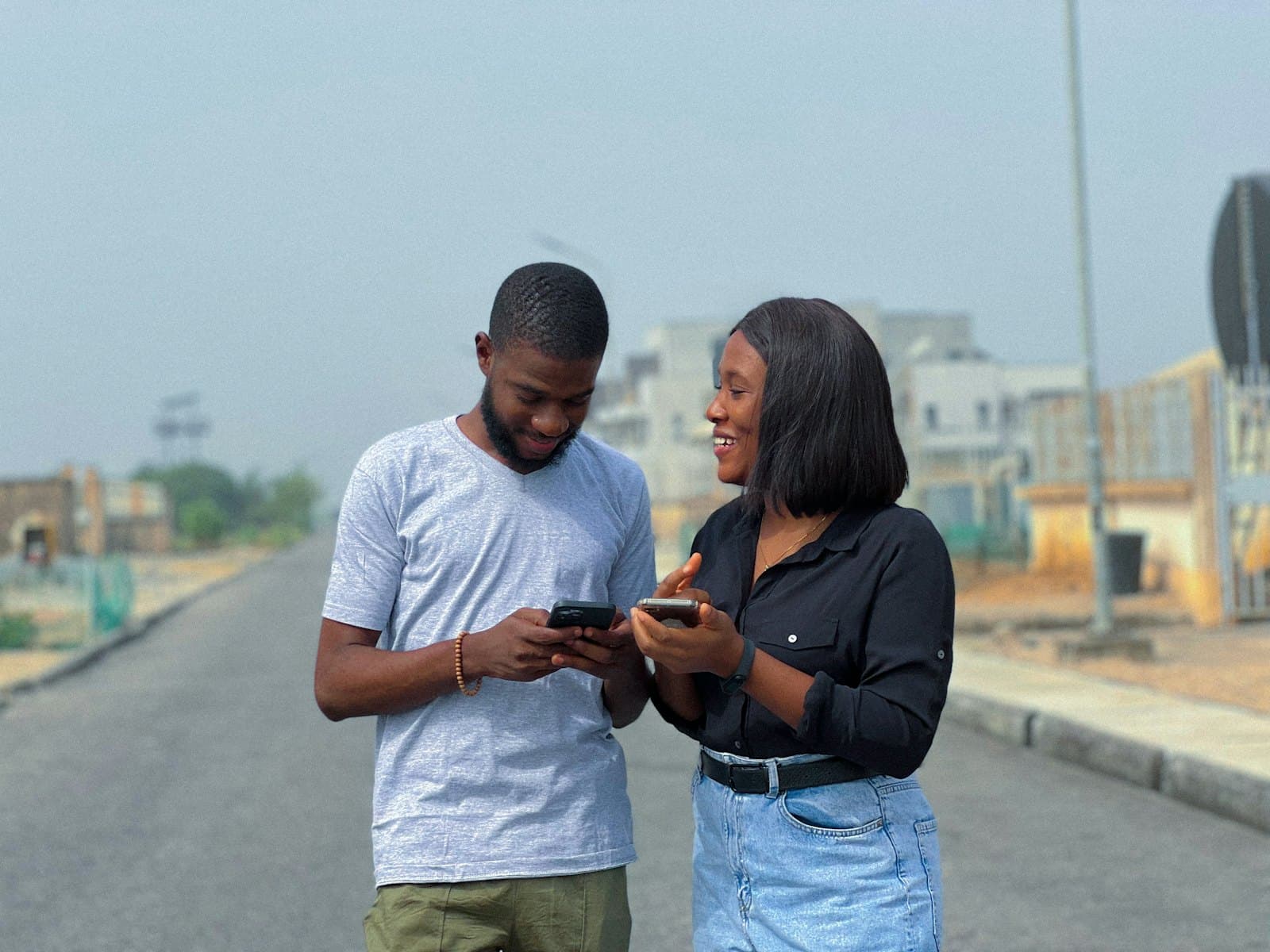 Two people in Lagos paying on their phones together